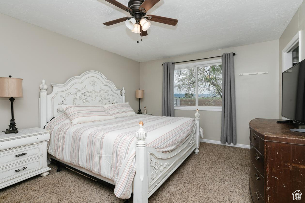 Bedroom featuring light colored carpet, baseboards, and ceiling fan