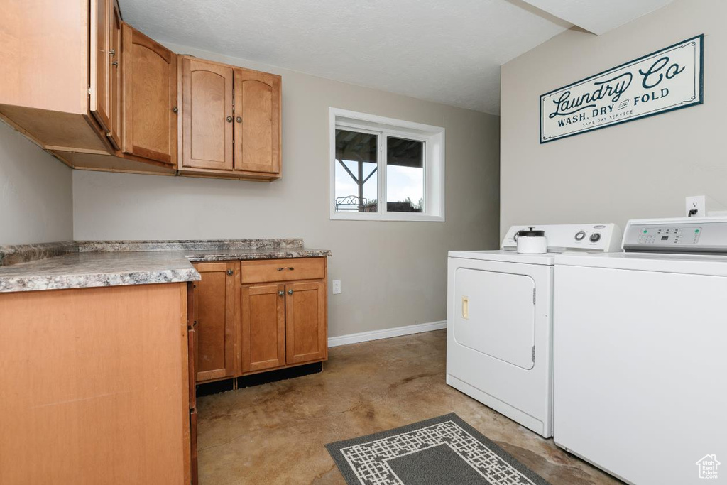 Washroom with washer and clothes dryer, cabinet space, and baseboards