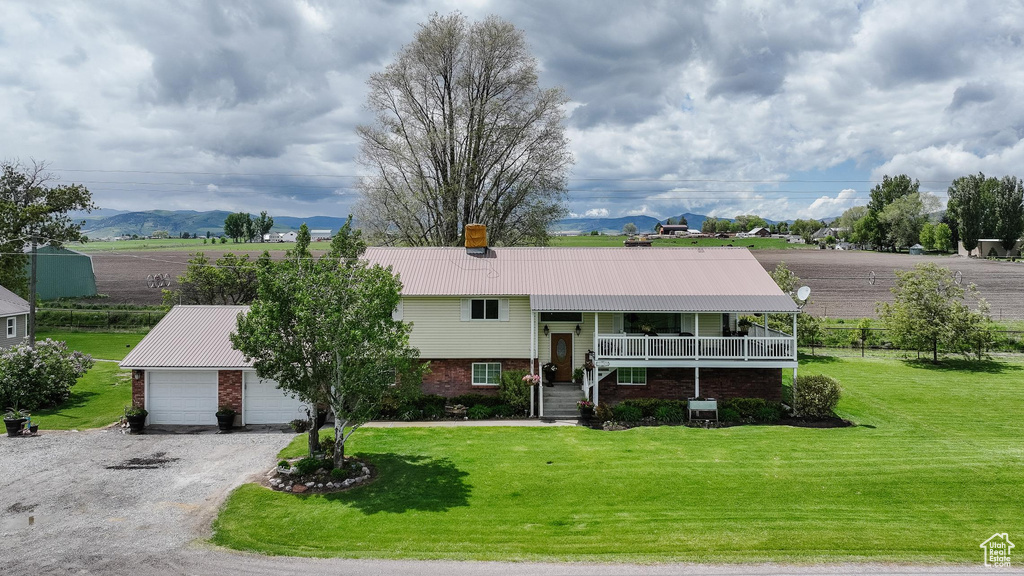 View of front of home with metal roof, a front yard, brick siding, and a chimney