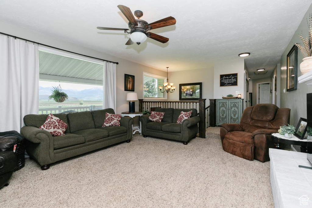 Carpeted living area featuring a chandelier and ceiling fan