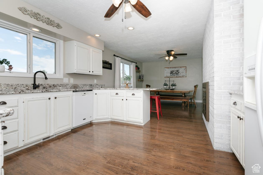 Kitchen with ceiling fan, white appliances, a peninsula, dark wood-style floors, and recessed lighting