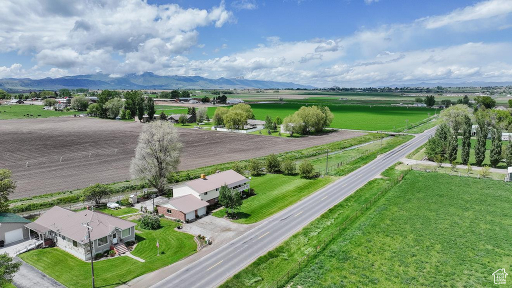 Aerial view of sparsely populated area featuring a mountainous background and extensive farmland