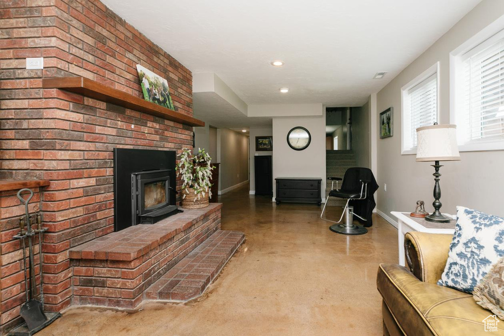 Living area featuring concrete floors, baseboards, a brick fireplace, and recessed lighting