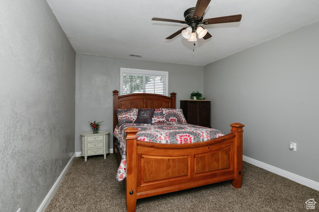 Carpeted bedroom with baseboards and a ceiling fan