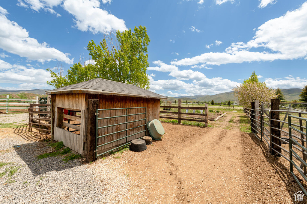 View of outbuilding featuring a view of rural / pastoral area, a mountain view, and an exterior structure