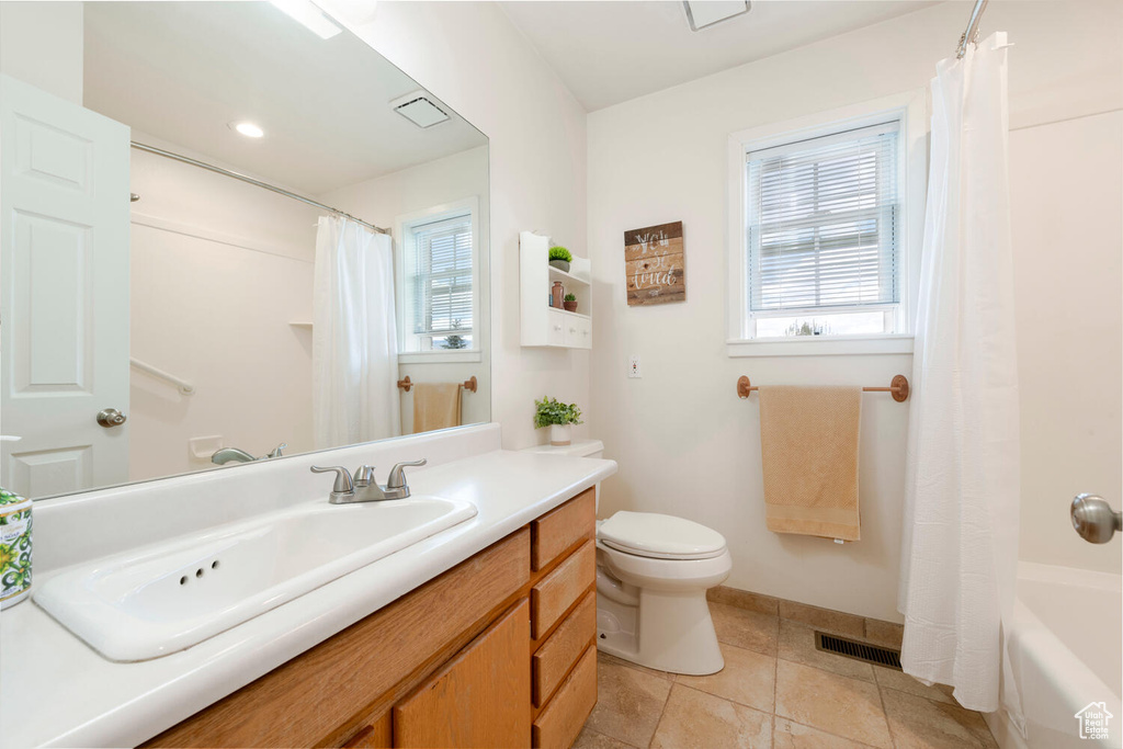 Bathroom with toilet, vanity, tile patterned flooring, and baseboards