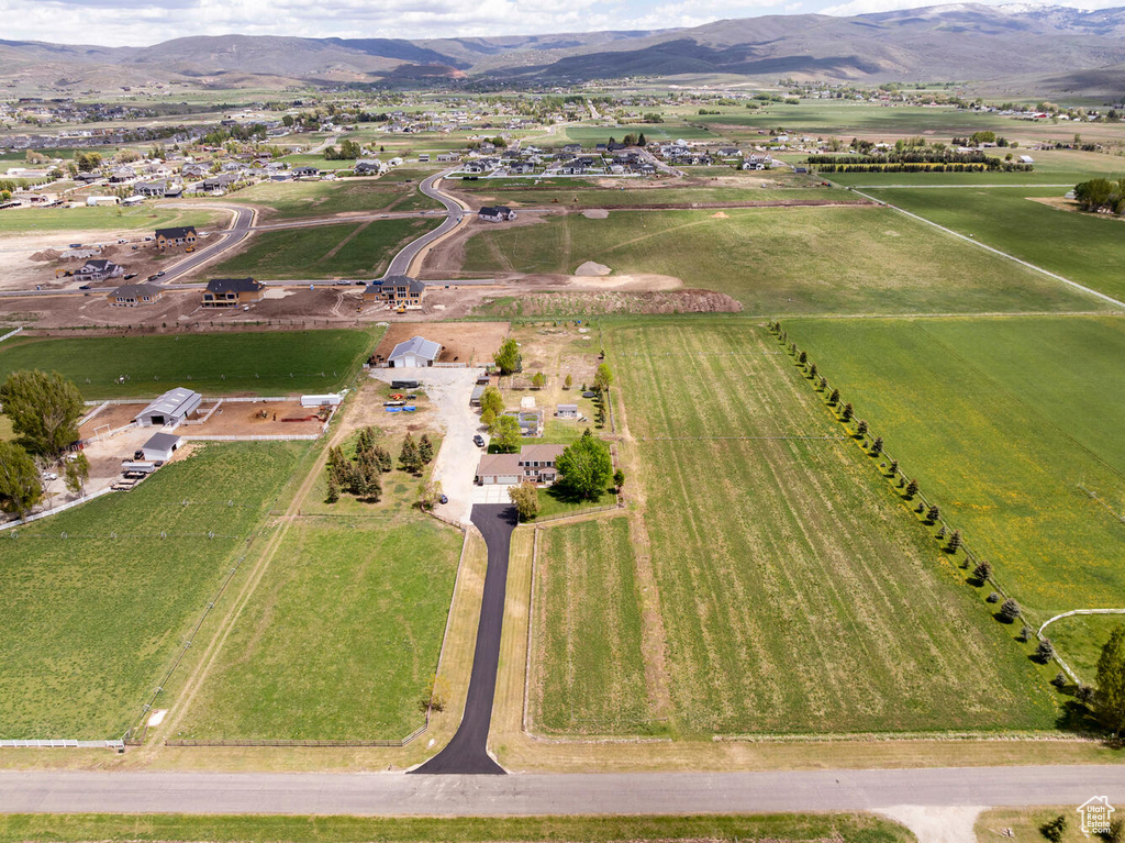 Aerial view of property and surrounding area featuring rural landscape, mountains, and farmland