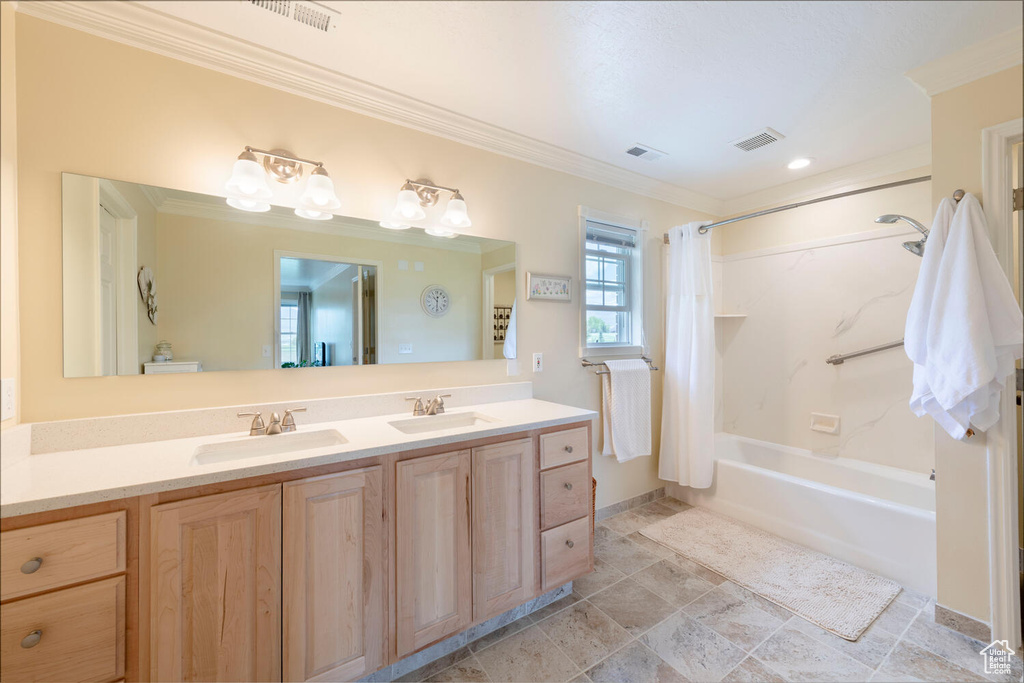 Full bathroom featuring shower / bath combo with shower curtain, double vanity, and ornamental molding