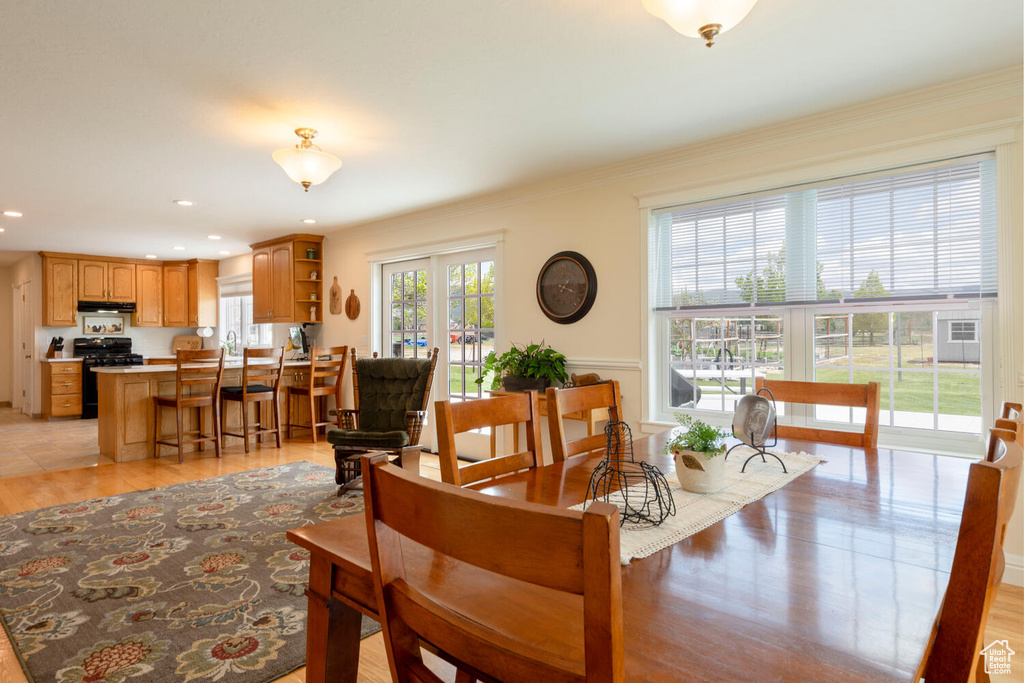 Dining area featuring recessed lighting, light wood-type flooring, and crown molding
