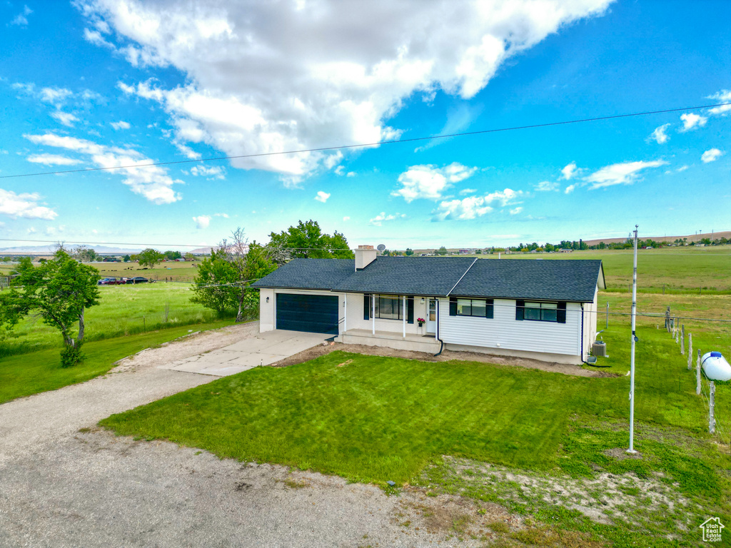 Ranch-style house featuring driveway, an attached garage, roof with shingles, and a chimney