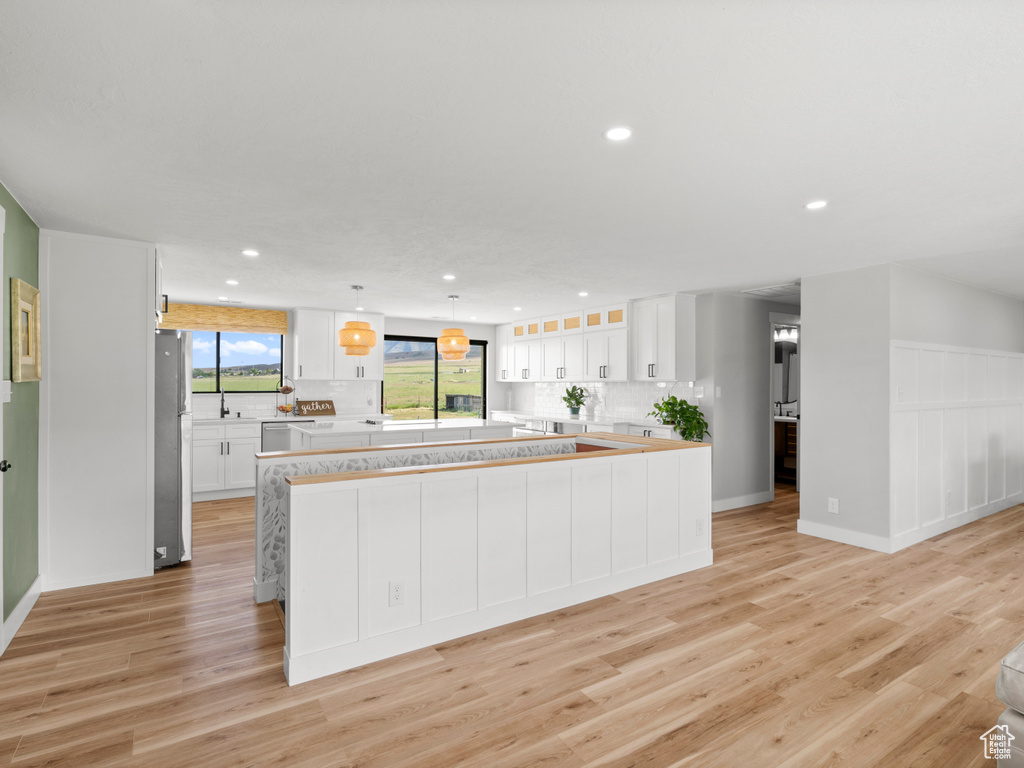 Kitchen featuring appliances with stainless steel finishes, recessed lighting, light countertops, tasteful backsplash, and light wood finished floors