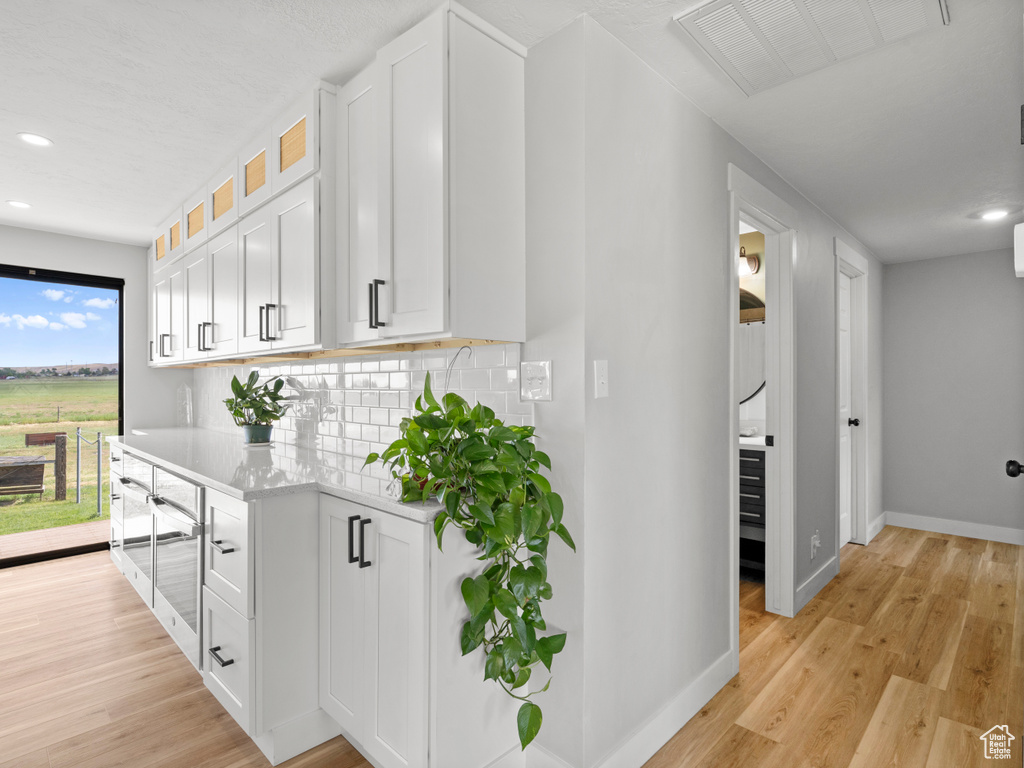 Hallway with baseboards, light wood-style flooring, and recessed lighting