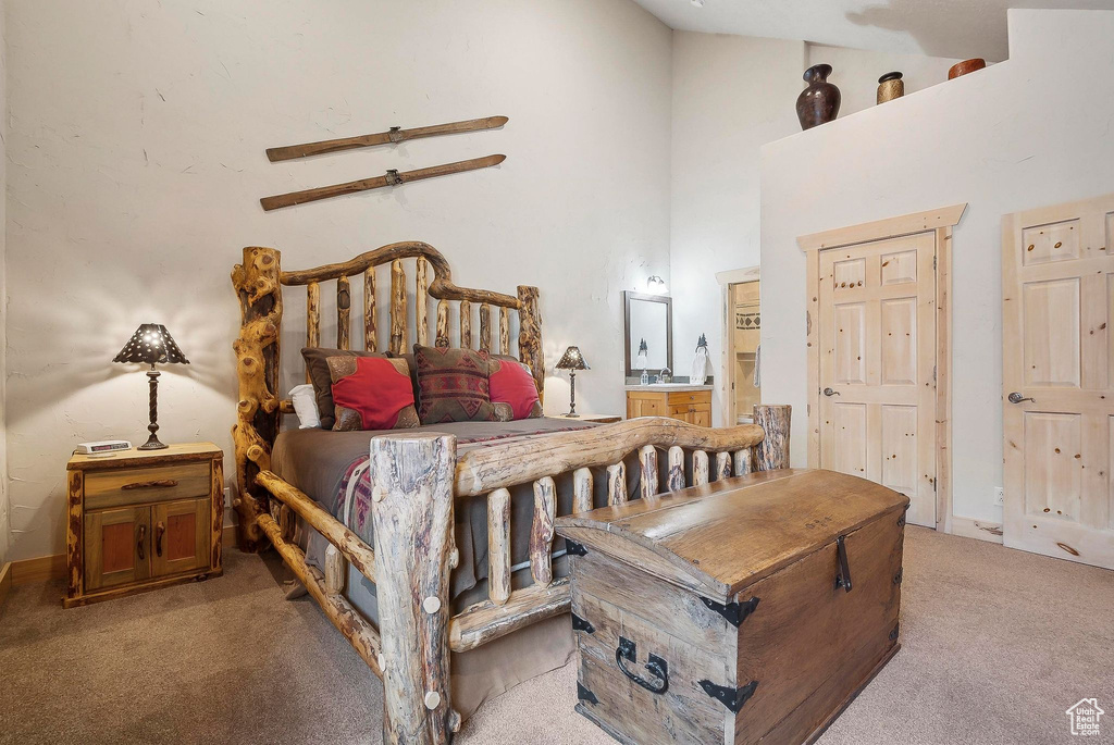Bedroom featuring light colored carpet, a high ceiling, ensuite bath, and ceiling fan