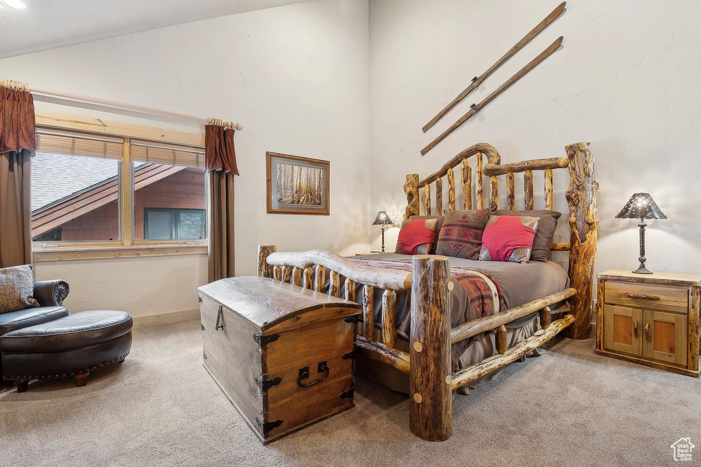 Bedroom featuring light colored carpet and vaulted ceiling