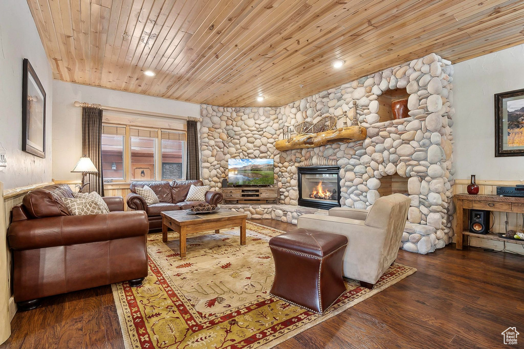Living room featuring wooden ceiling, wood finished floors, a stone fireplace, and recessed lighting