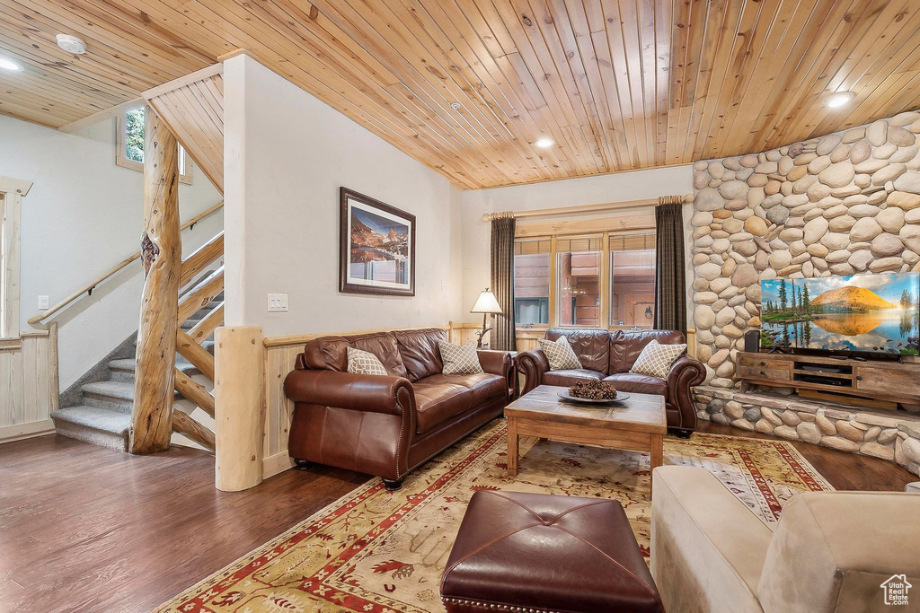 Living room featuring wood ceiling, wood finished floors, stairs, recessed lighting, and wainscoting