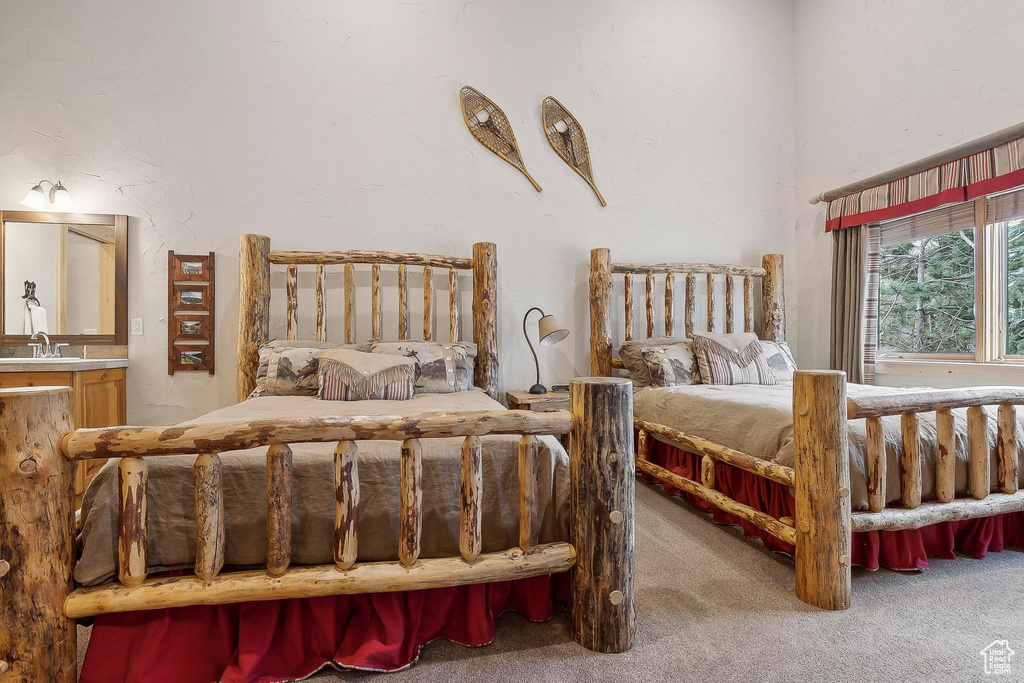 Bedroom featuring carpet floors, a sink, and ensuite bath