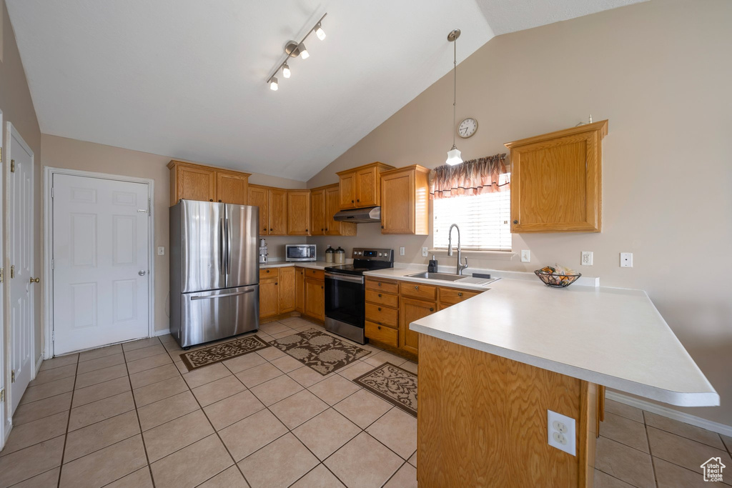 Kitchen featuring stainless steel appliances, under cabinet range hood, a sink, a peninsula, and light countertops