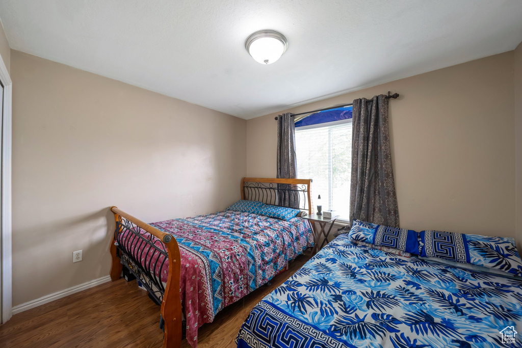 Bedroom featuring wood finished floors and baseboards