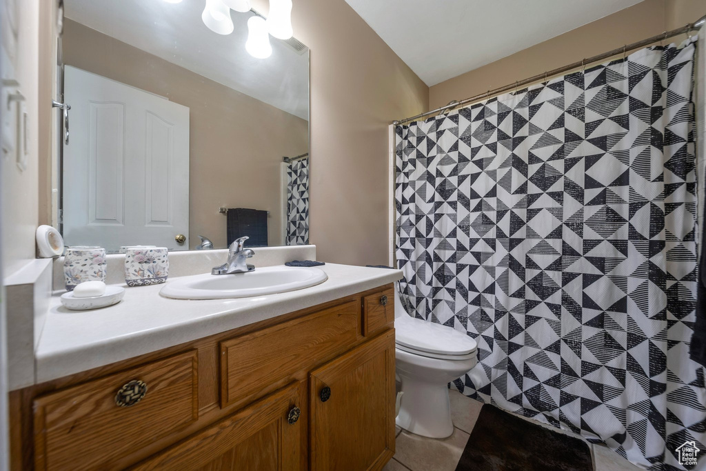 Bathroom featuring vanity, toilet, tile patterned flooring, and a shower with shower curtain