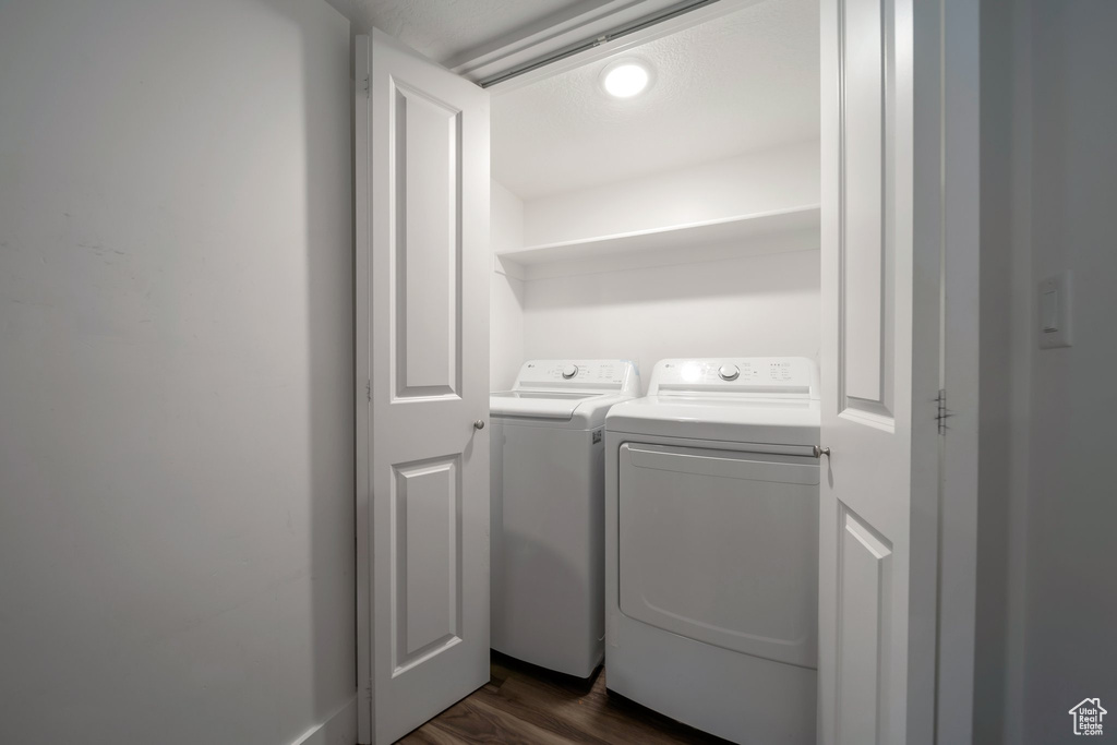 Washroom with independent washer and dryer and dark wood finished floors