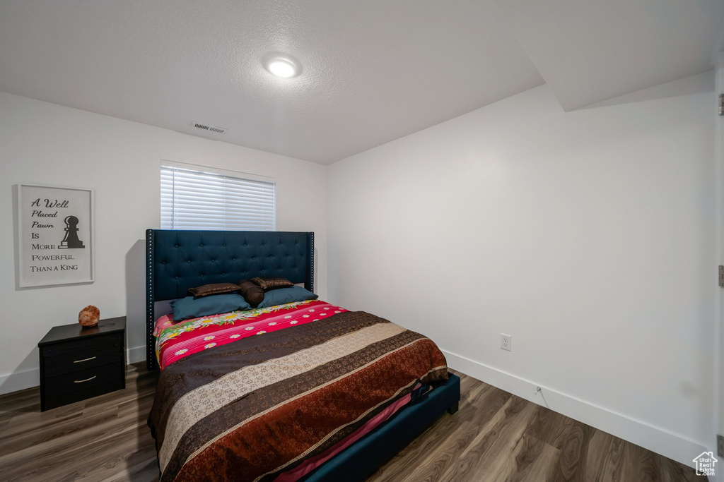 Bedroom with wood finished floors and baseboards