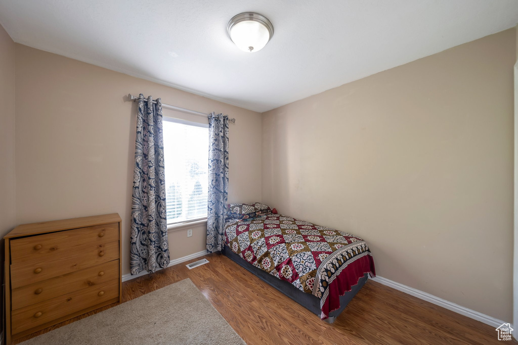 Bedroom with wood finished floors and baseboards