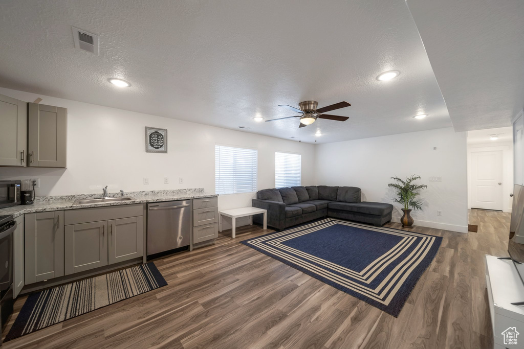 Living room featuring ceiling fan, dark wood finished floors, recessed lighting, and a textured ceiling