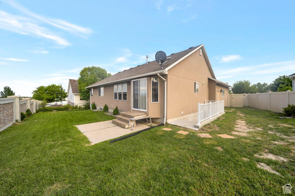 Back of property with stucco siding and a patio area