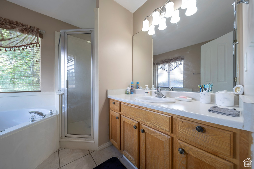 Bathroom with vanity, a stall shower, tile patterned flooring, and a bath