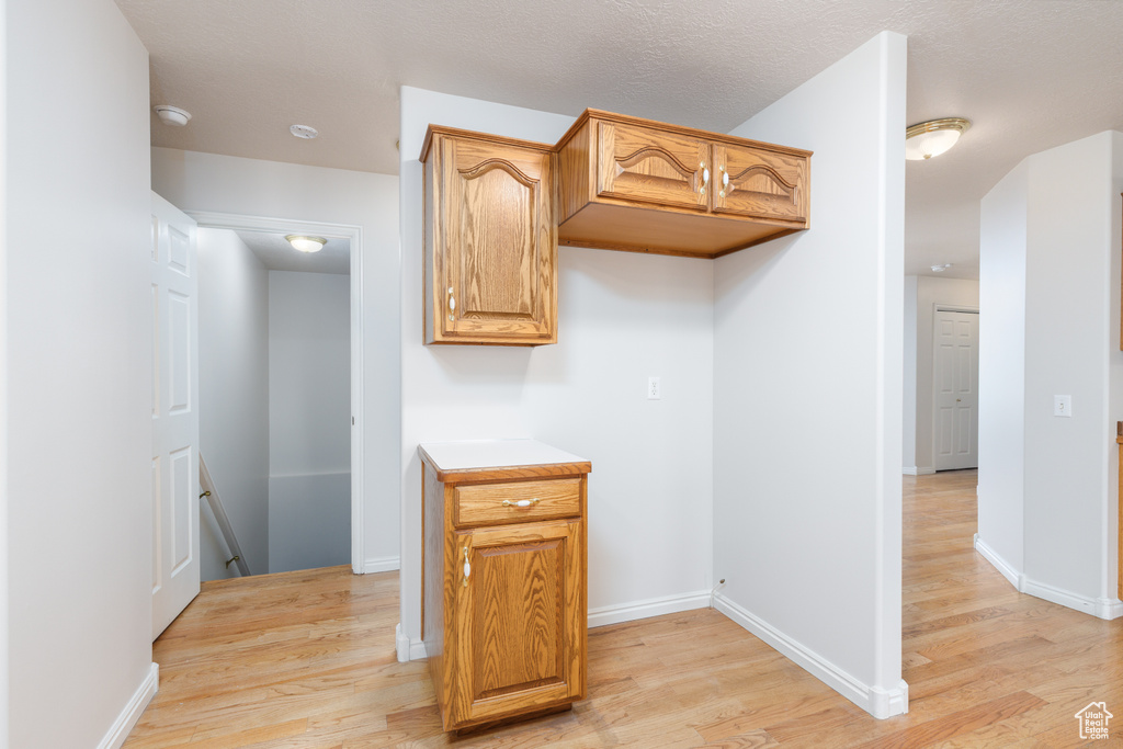 Kitchen with light wood-style floors, light countertops, and baseboards