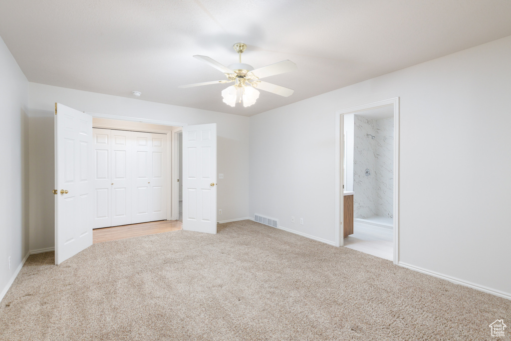 Unfurnished bedroom with carpet, baseboards, a closet, and ensuite bath