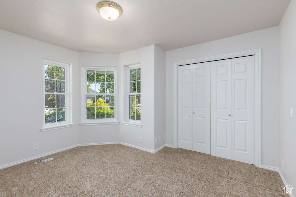 Unfurnished bedroom with carpet, baseboards, and a closet