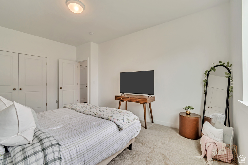 Carpeted bedroom featuring a closet and baseboards