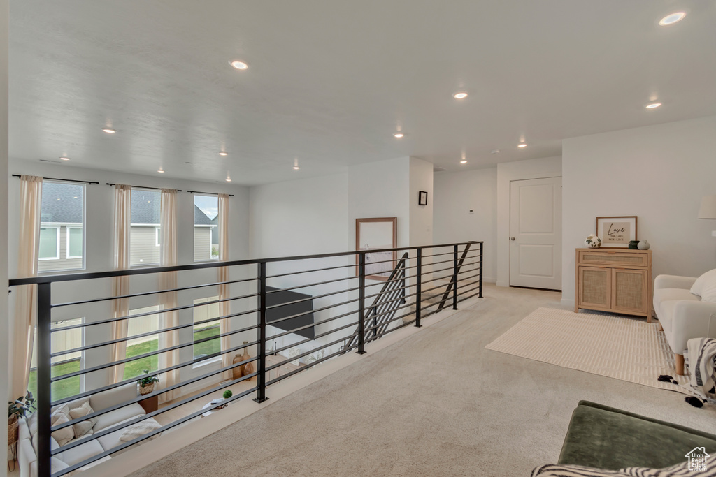 Hall with an upstairs landing, carpet floors, and recessed lighting