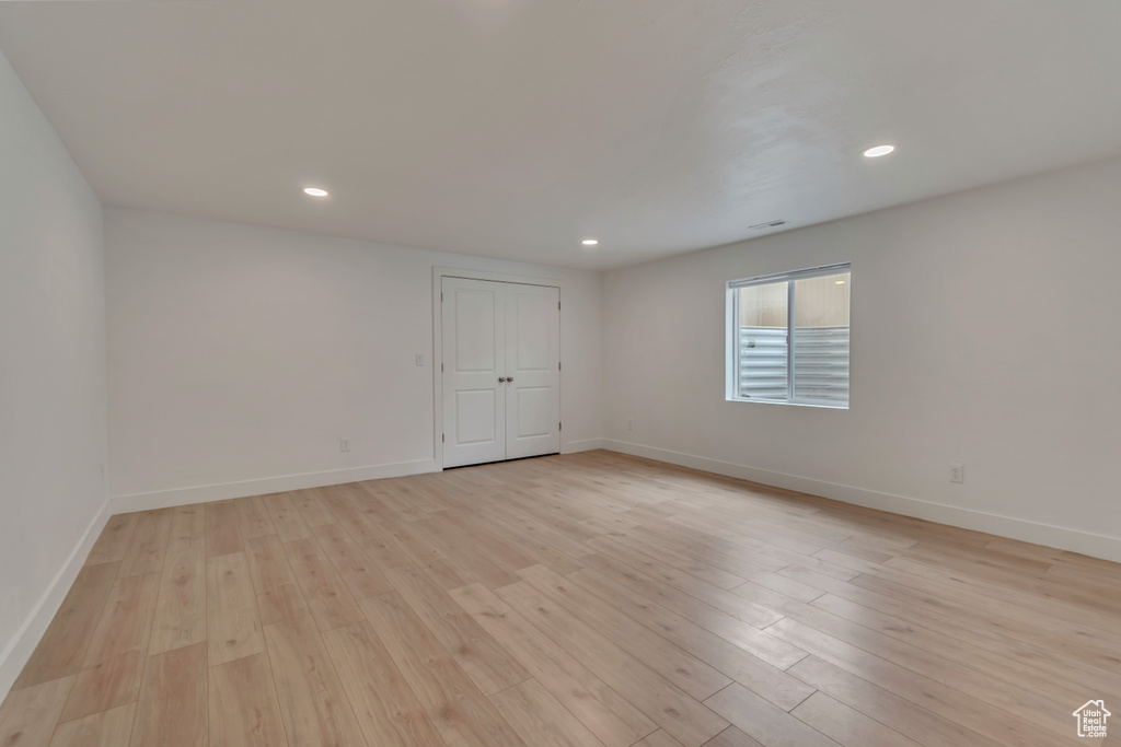 Spare room with light wood-style flooring, baseboards, and recessed lighting