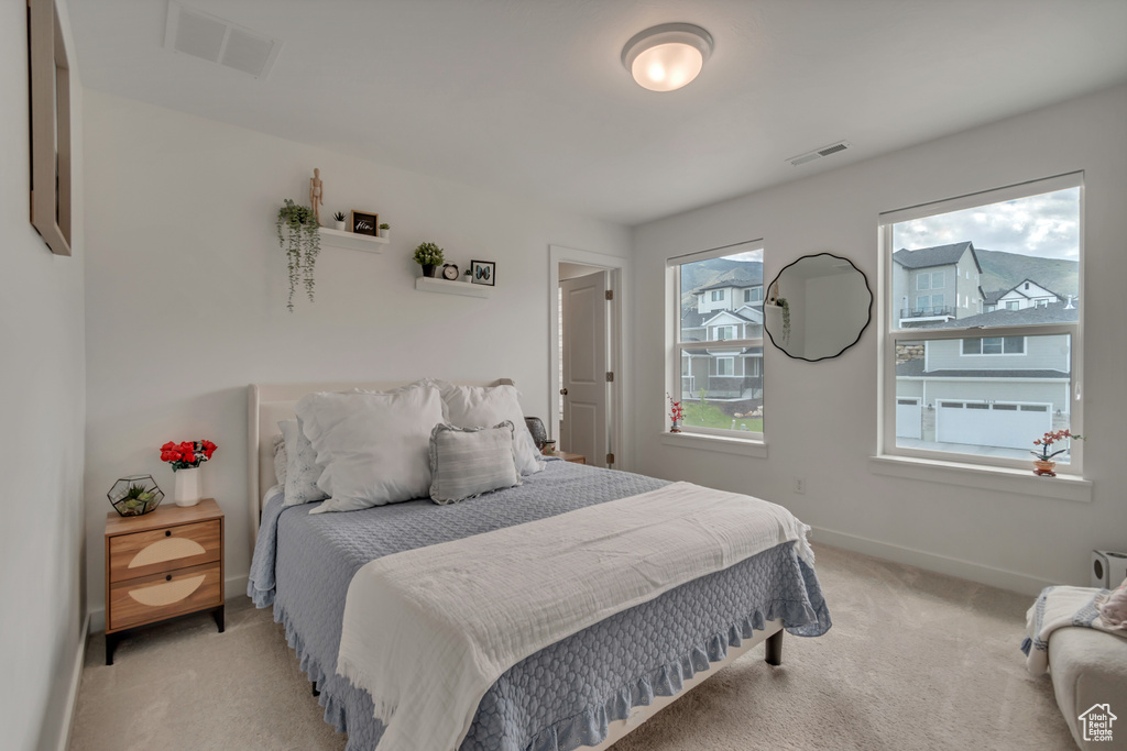 Bedroom with light colored carpet and baseboards