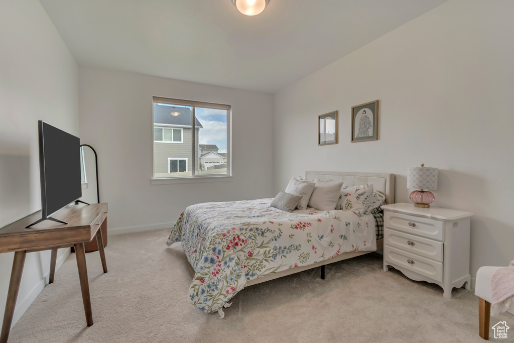 Bedroom with light carpet and baseboards
