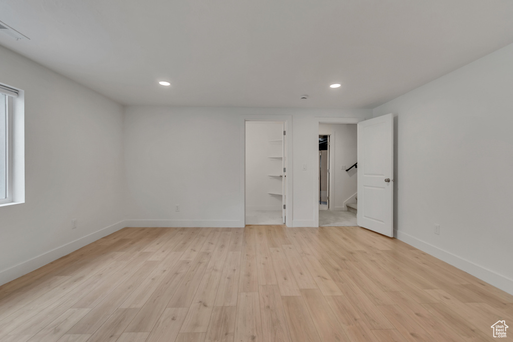 Unfurnished bedroom featuring recessed lighting, light wood-type flooring, baseboards, and a spacious closet