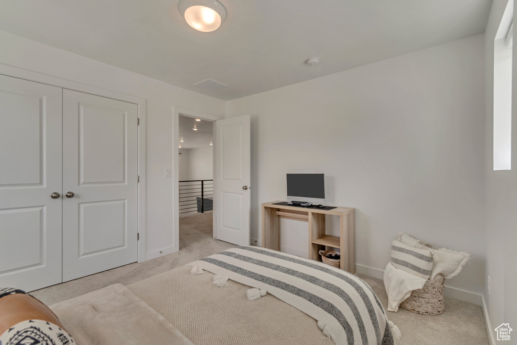 Carpeted bedroom featuring baseboards and a closet