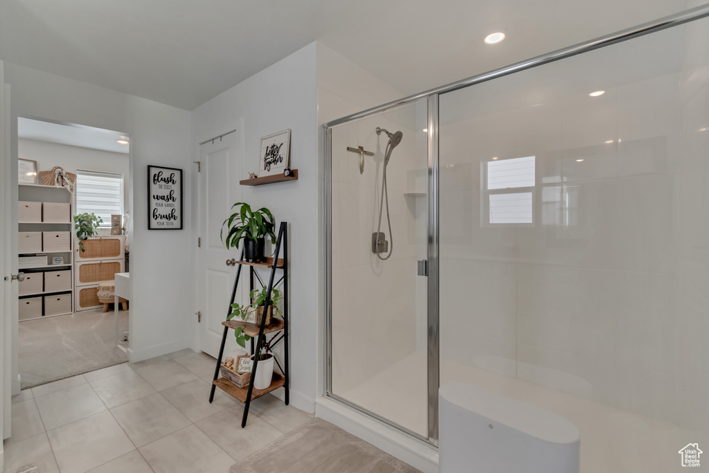 Bathroom with a stall shower and tile patterned floors