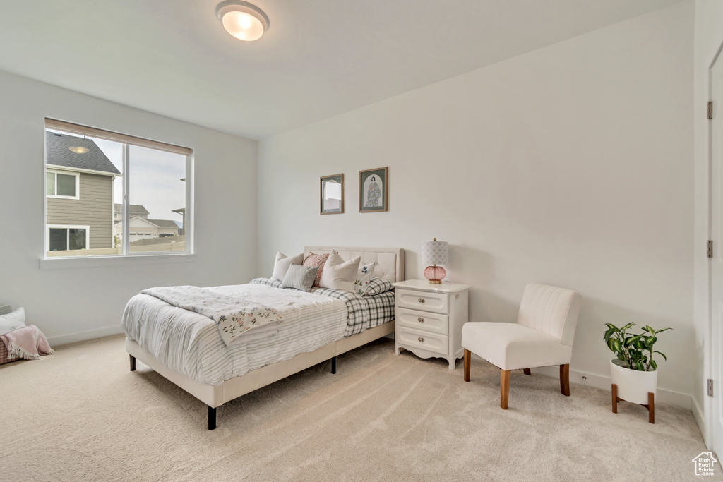 Bedroom featuring light carpet and baseboards