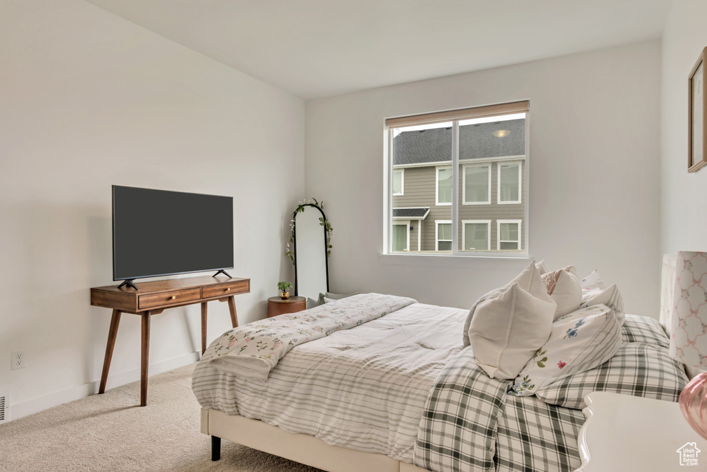 Bedroom featuring carpet and baseboards