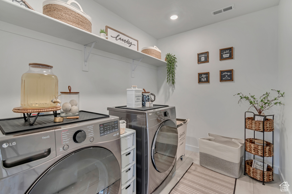 Clothes washing area featuring washing machine and clothes dryer, light tile patterned floors, recessed lighting, and baseboards
