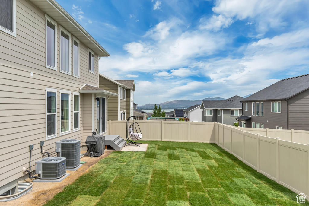 View of yard featuring a mountain view, central AC unit, and a residential view