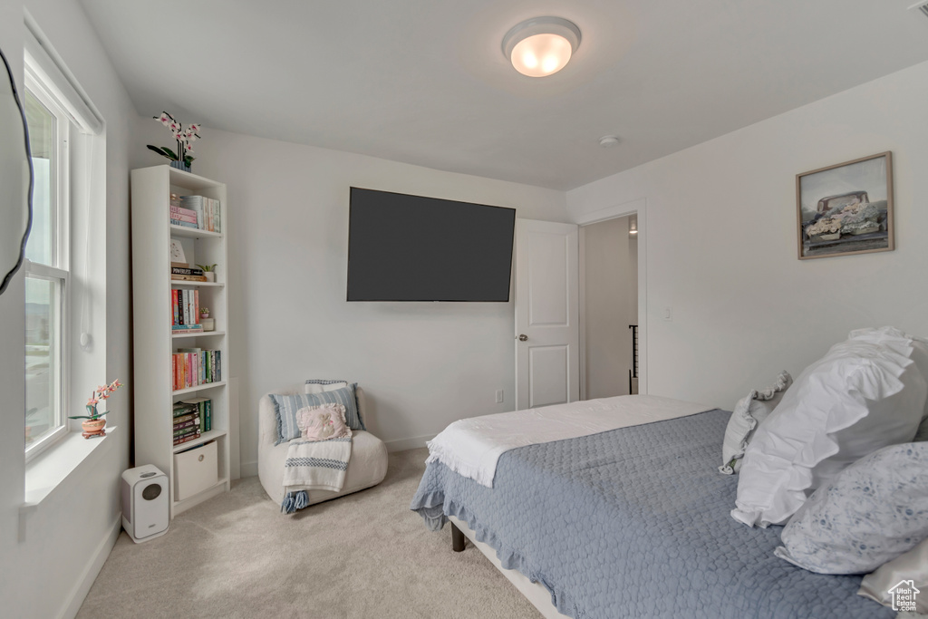 Carpeted bedroom featuring multiple windows and baseboards