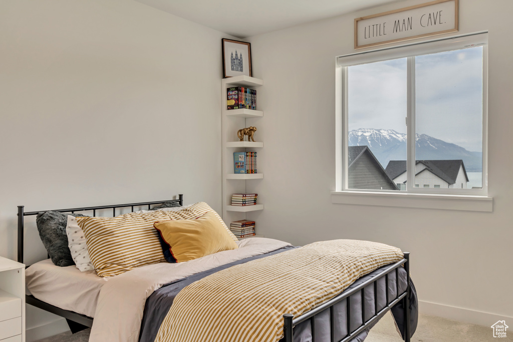 Carpeted bedroom with a mountain view and baseboards