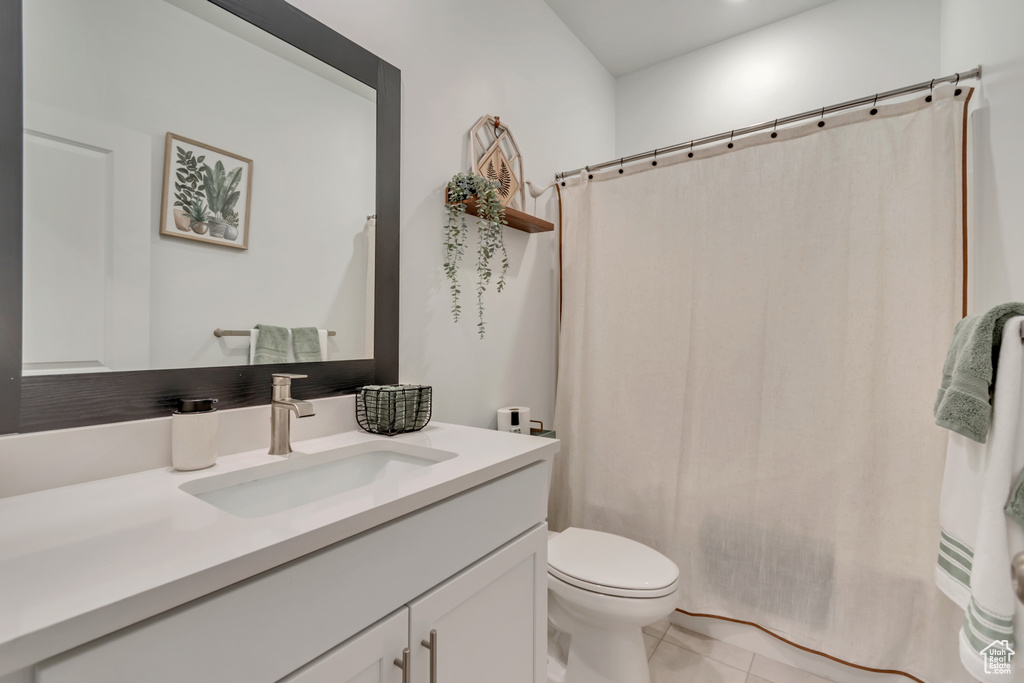 Full bathroom with tile patterned flooring, vanity, toilet, and curtained shower