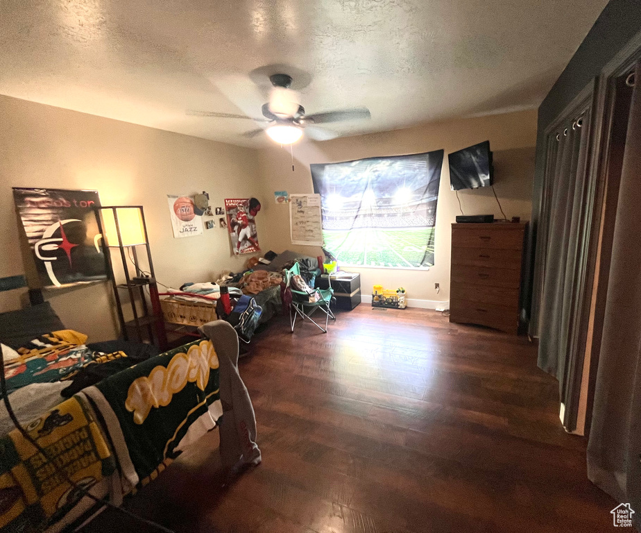 Bedroom with wood finished floors, a textured ceiling, and ceiling fan