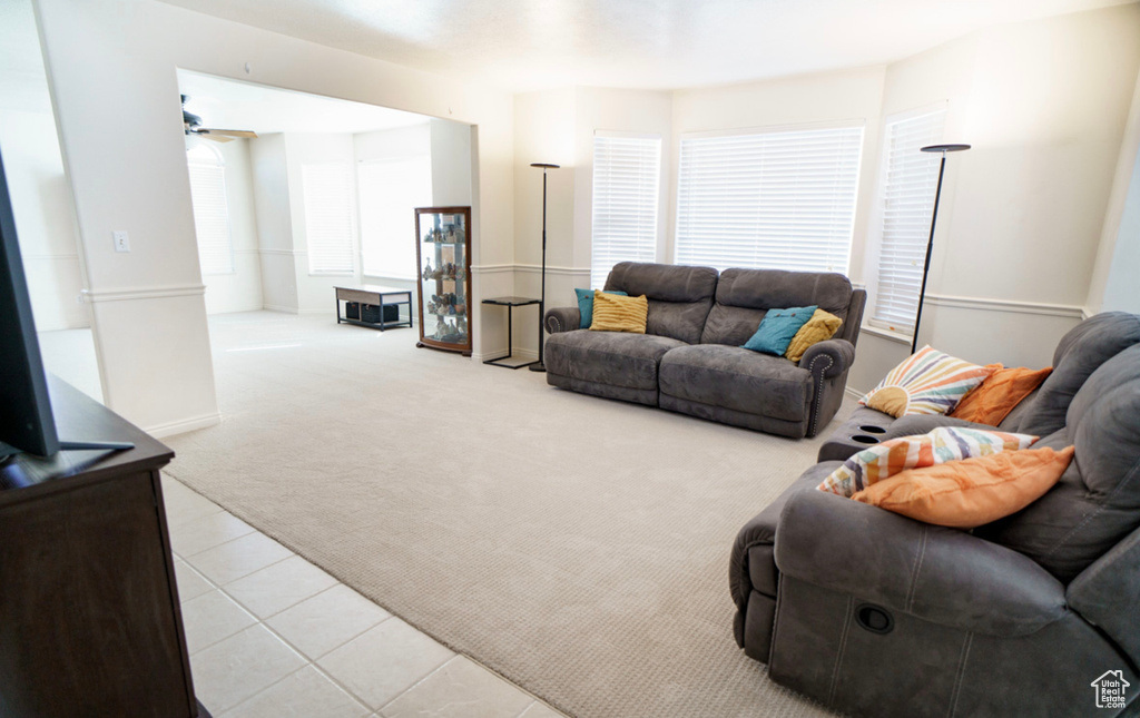 Carpeted living room featuring a ceiling fan